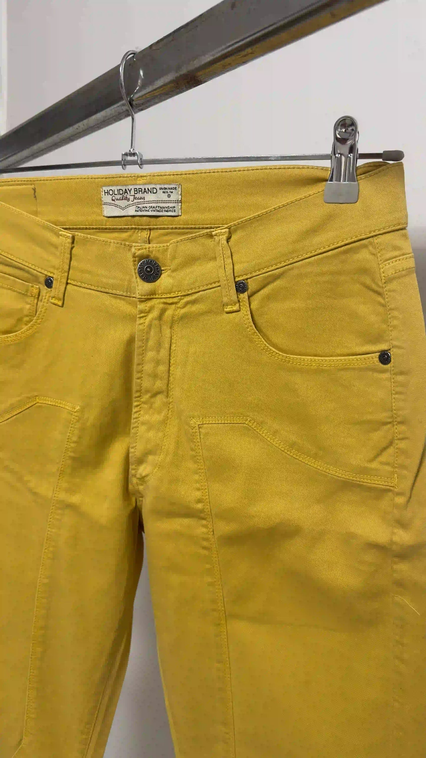 Dettaglio etichetta Holiday Brand cucita sulla cintura del pantalone ocra