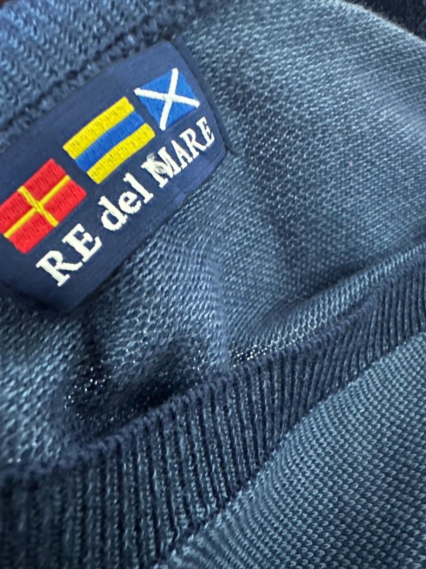 Dettaglio etichetta RE del MARE cucita sul pullover blu avio, con bandiere e logo ricamato